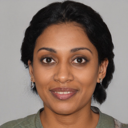 Joyful black young-adult female with medium  black hair and brown eyes