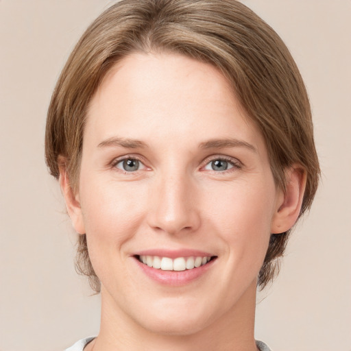 Joyful white young-adult female with medium  brown hair and green eyes