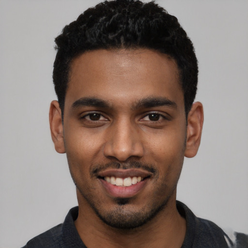 Joyful black young-adult male with short  black hair and brown eyes