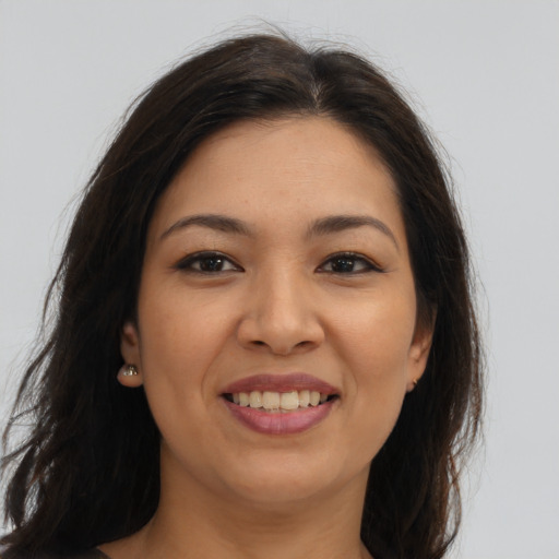 Joyful latino young-adult female with long  brown hair and brown eyes