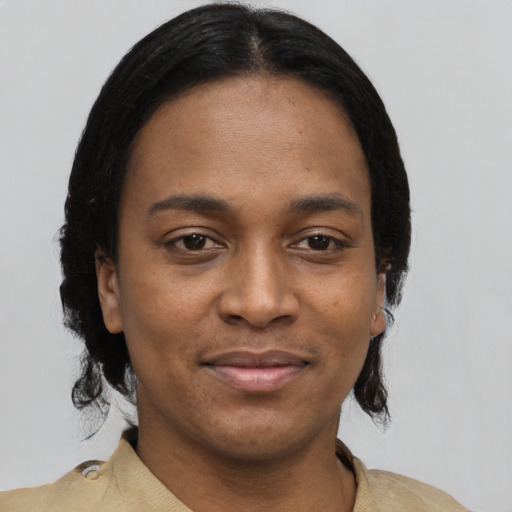 Joyful black young-adult female with short  black hair and brown eyes