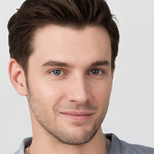 Joyful white young-adult male with short  brown hair and grey eyes