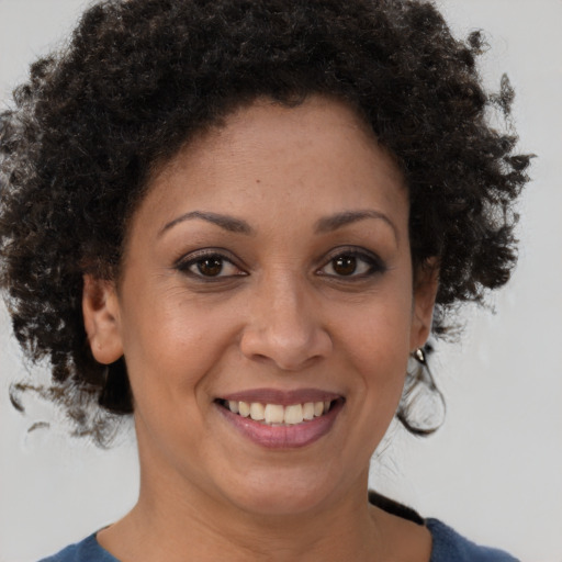 Joyful black adult female with short  brown hair and brown eyes