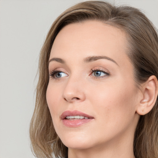 Joyful white young-adult female with long  brown hair and blue eyes