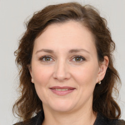 Joyful white adult female with medium  brown hair and grey eyes