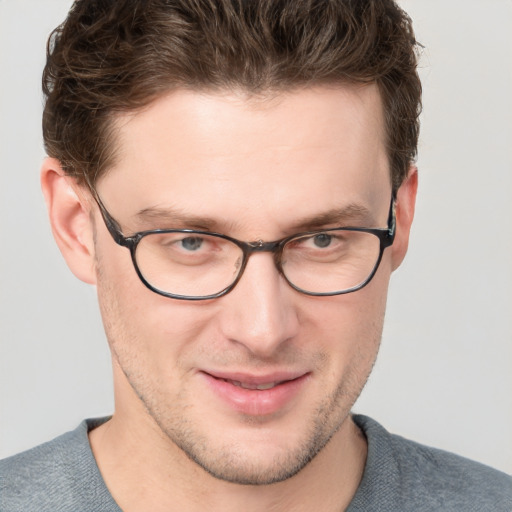 Joyful white young-adult male with short  brown hair and blue eyes