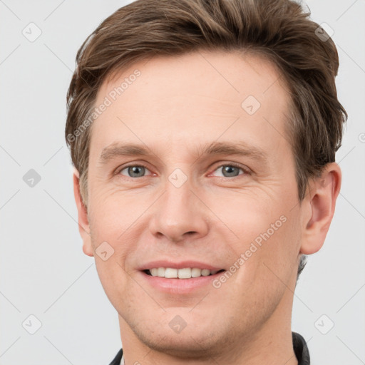 Joyful white adult male with short  brown hair and grey eyes