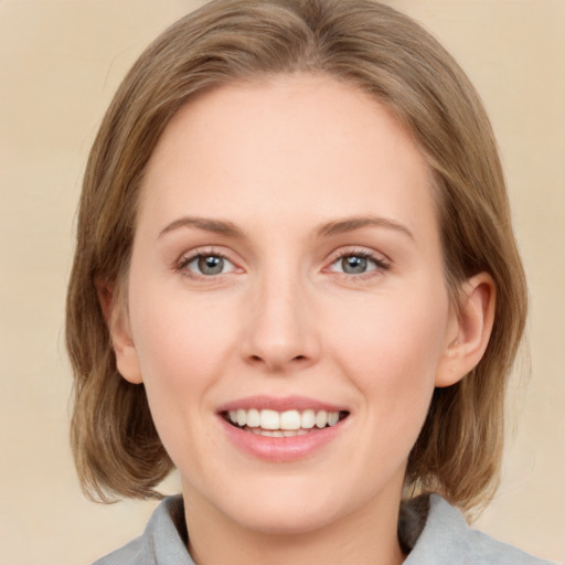 Joyful white young-adult female with medium  brown hair and green eyes