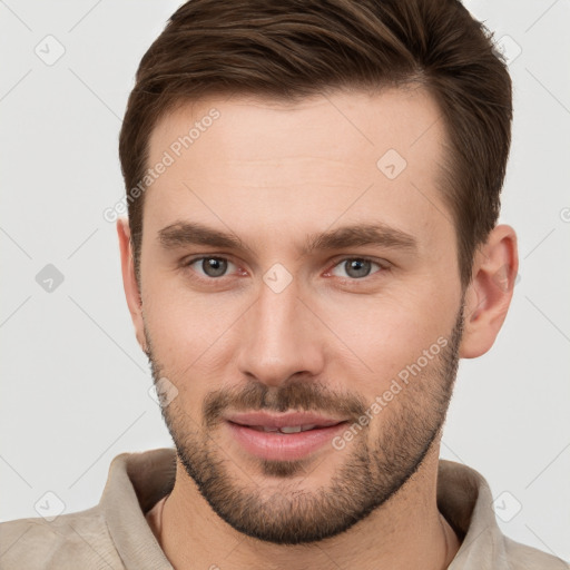 Joyful white young-adult male with short  brown hair and grey eyes