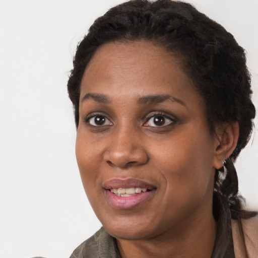 Joyful black young-adult female with long  brown hair and brown eyes