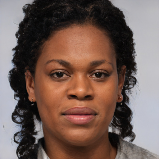 Joyful black young-adult female with long  brown hair and brown eyes