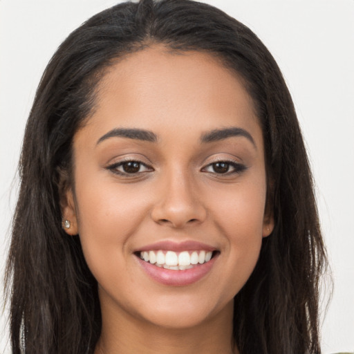 Joyful latino young-adult female with long  brown hair and brown eyes