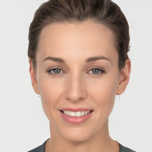 Joyful white young-adult female with short  brown hair and grey eyes