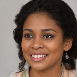 Joyful black young-adult female with long  brown hair and brown eyes