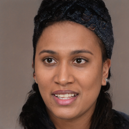 Joyful black young-adult female with long  black hair and brown eyes