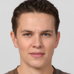 Joyful white young-adult male with short  brown hair and grey eyes