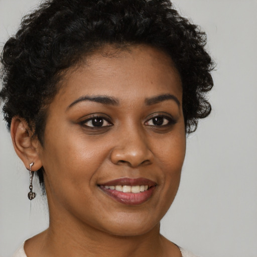 Joyful black young-adult female with short  brown hair and brown eyes