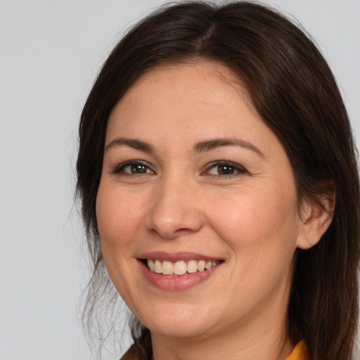 Joyful white adult female with long  brown hair and brown eyes