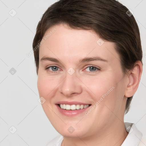 Joyful white young-adult female with short  brown hair and grey eyes