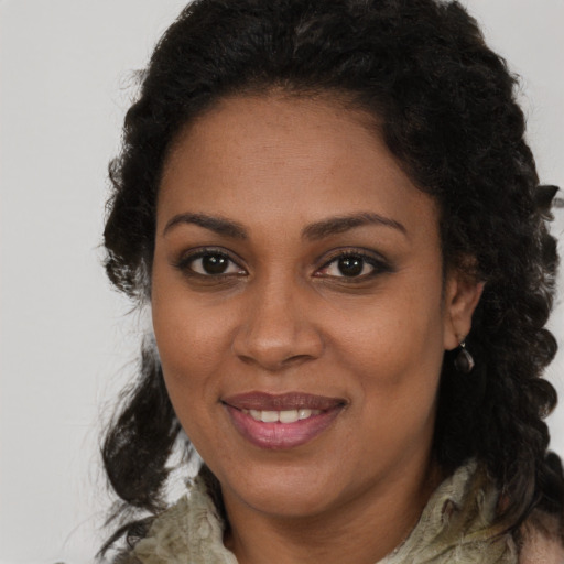 Joyful black young-adult female with long  brown hair and brown eyes