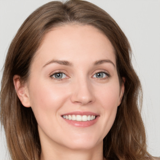 Joyful white young-adult female with long  brown hair and grey eyes