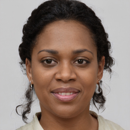Joyful black young-adult female with medium  brown hair and brown eyes