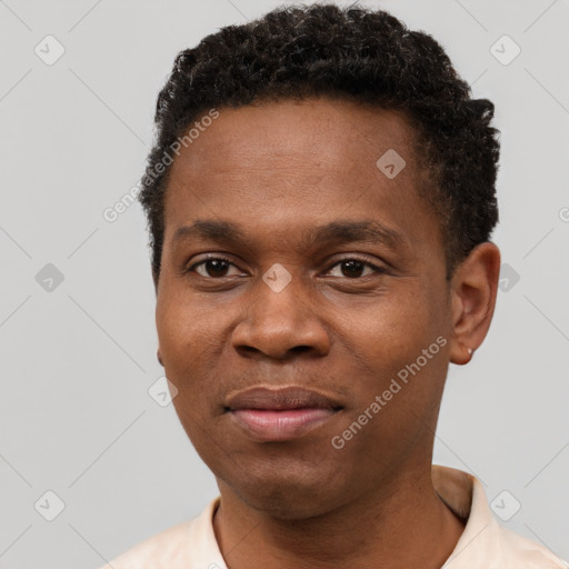 Joyful black young-adult male with short  brown hair and brown eyes