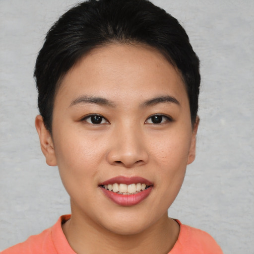 Joyful asian young-adult female with short  brown hair and brown eyes