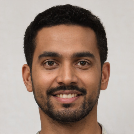 Joyful latino young-adult male with short  black hair and brown eyes