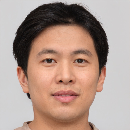 Joyful asian young-adult male with short  brown hair and brown eyes