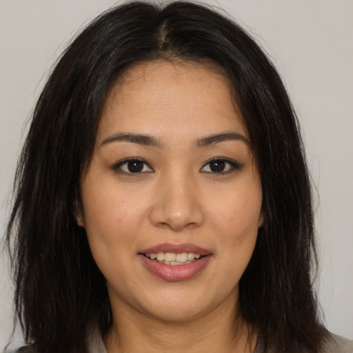Joyful asian young-adult female with long  brown hair and brown eyes