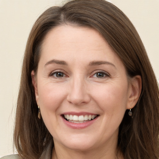 Joyful white adult female with long  brown hair and grey eyes