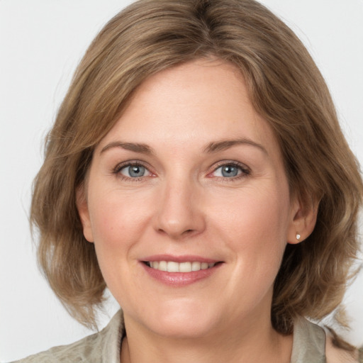 Joyful white adult female with medium  brown hair and blue eyes