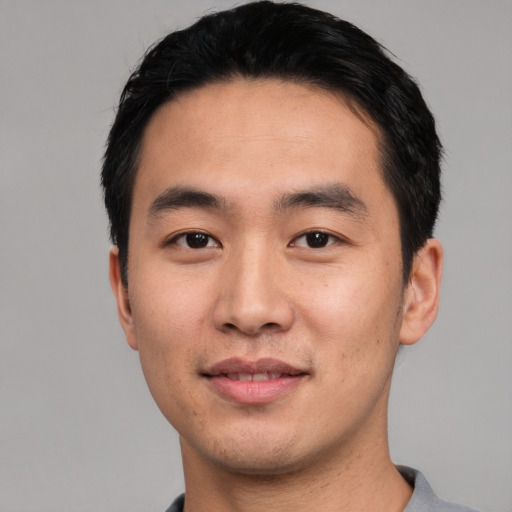 Joyful asian young-adult male with short  black hair and brown eyes