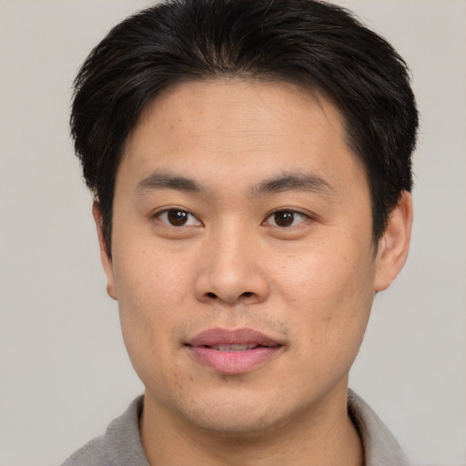 Joyful asian young-adult male with short  brown hair and brown eyes