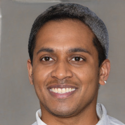 Joyful latino young-adult male with short  black hair and brown eyes