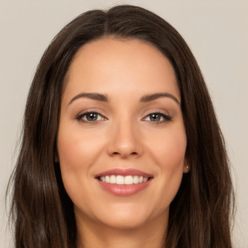 Joyful white young-adult female with long  brown hair and brown eyes