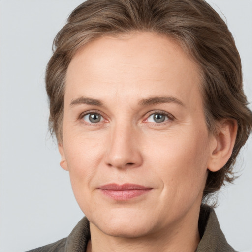 Joyful white adult female with medium  brown hair and grey eyes