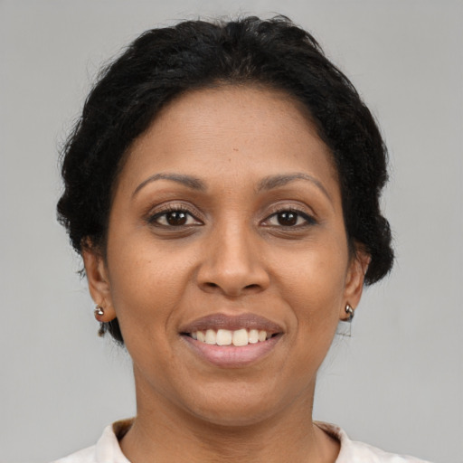 Joyful latino adult female with short  brown hair and brown eyes