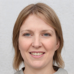 Joyful white adult female with medium  brown hair and grey eyes