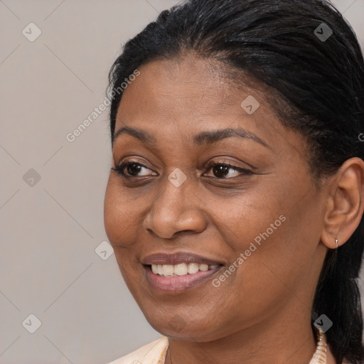 Joyful black adult female with medium  brown hair and brown eyes