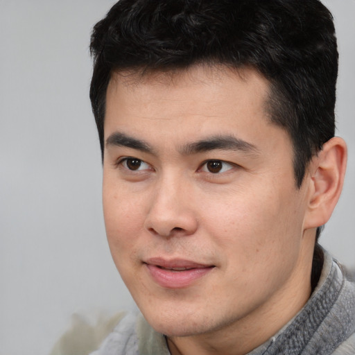 Joyful asian young-adult male with short  black hair and brown eyes