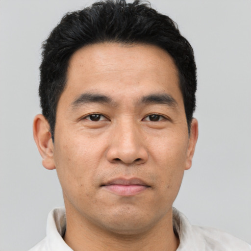 Joyful asian young-adult male with short  brown hair and brown eyes