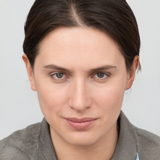 Joyful white young-adult female with medium  brown hair and grey eyes