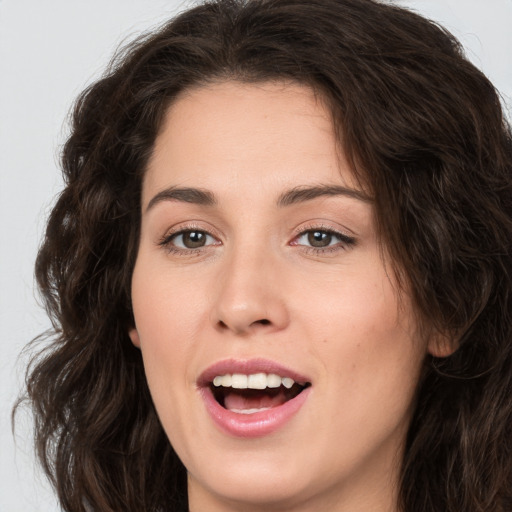 Joyful white young-adult female with long  brown hair and brown eyes