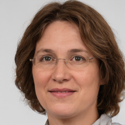 Joyful white adult female with medium  brown hair and green eyes