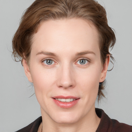 Joyful white young-adult female with medium  brown hair and blue eyes