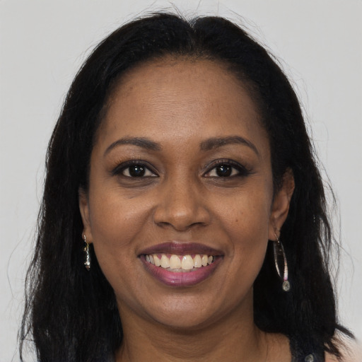 Joyful black adult female with long  brown hair and brown eyes