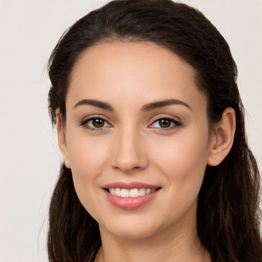 Joyful white young-adult female with long  brown hair and brown eyes