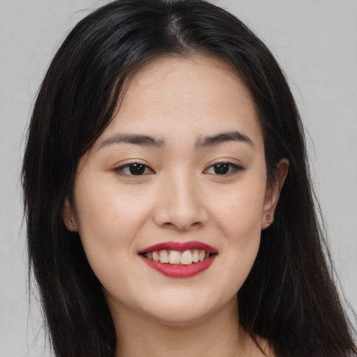 Joyful asian young-adult female with long  brown hair and brown eyes